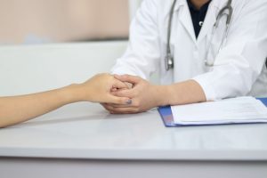 Médecin Tenant la Main d'une Patiente